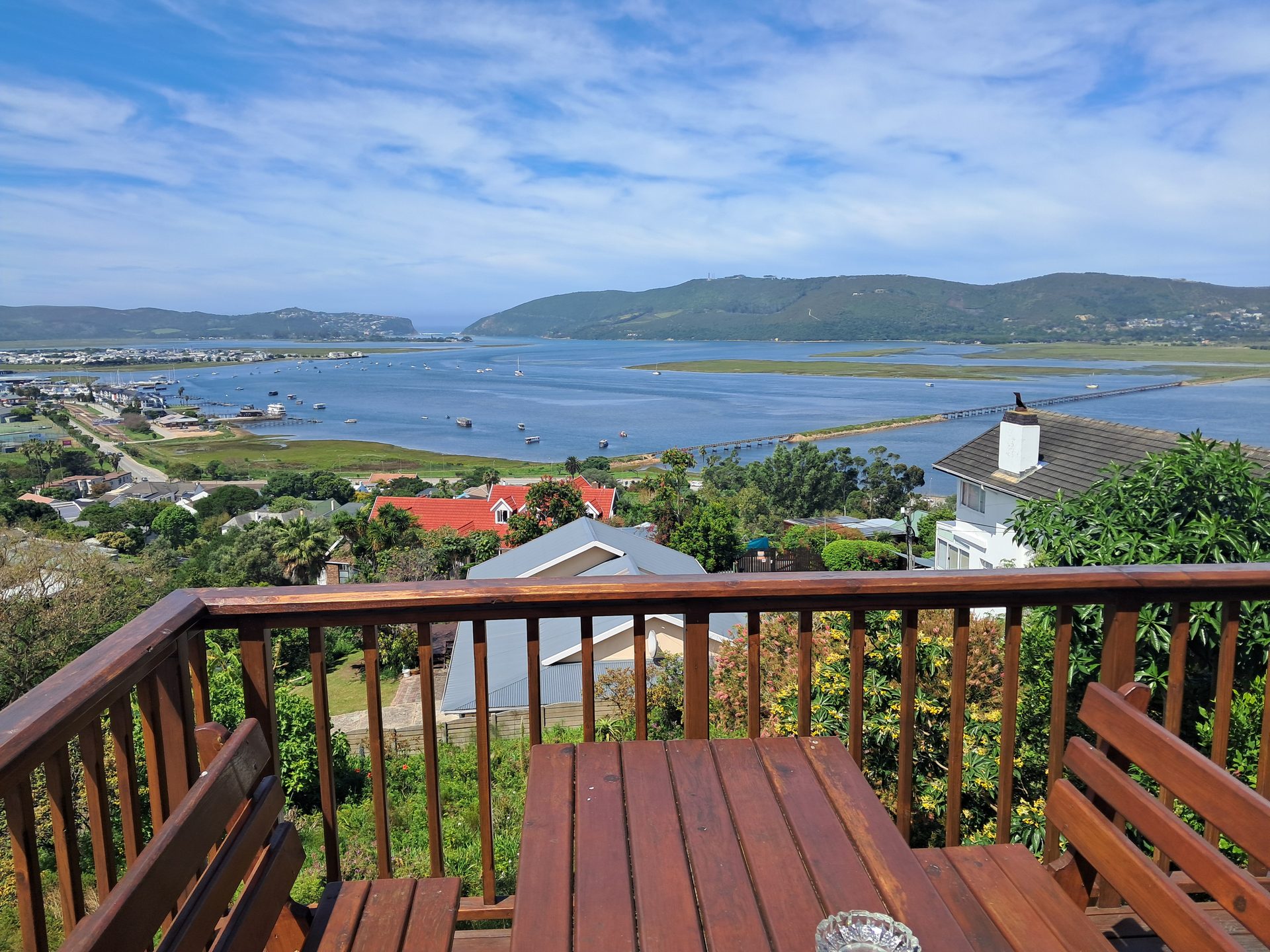 Wooden dining table and benches on the deck at Knysna Paradise Guesthouse