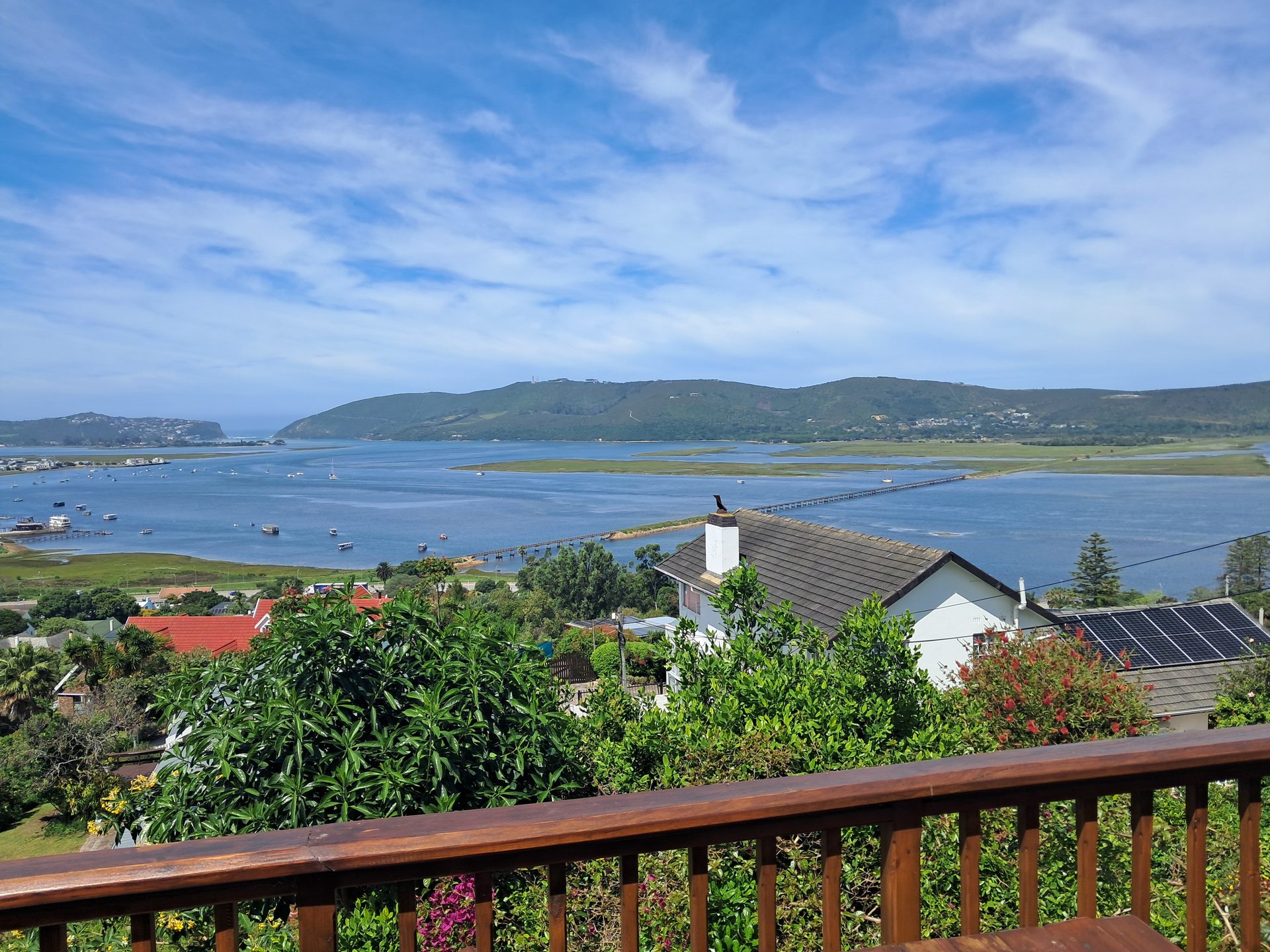 Looking down from the balcony at Knysna Paradise over trees, rooftops and the Knysna Lagoon